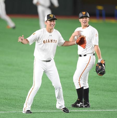 ノックを受ける巨人・坂本勇人（左）。右は巨人・炭谷銀仁朗＝東京ドーム（撮影・中田匡峻）