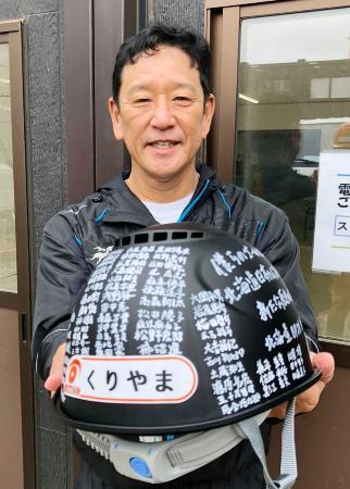 　作業員から贈られたメッセージ入りヘルメットを手に、笑顔の日本ハム・栗山監督＝２９日、北海道北広島市（球団提供）