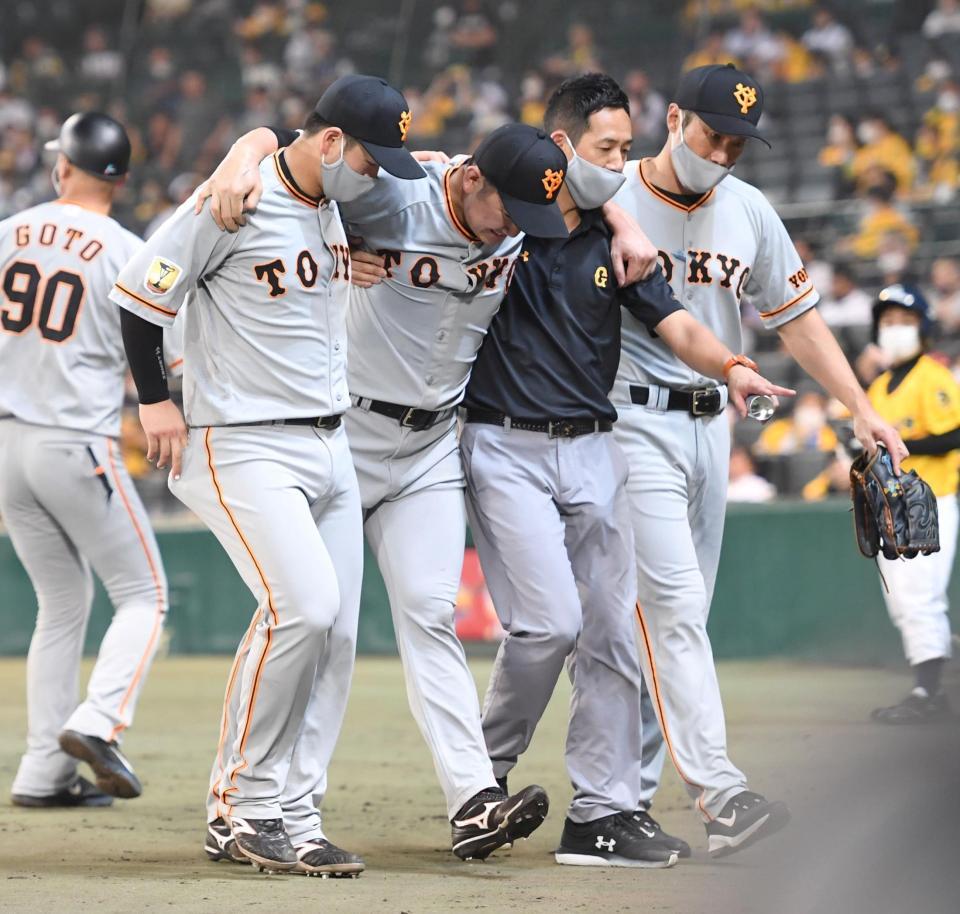 　７回、梅野の打球が強襲し、肩を担がれベンチへ戻る菅野（右から３人目）＝撮影・飯室逸平