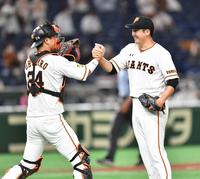 完封で開幕８連勝し、大城（左）とガッチリ握手する巨人・菅野＝東京ドーム（撮影・西岡正）