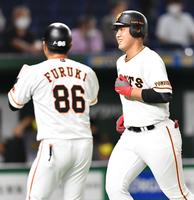 ４回、先制ソロを放ち、笑顔で生還する巨人・岡本（右）＝東京ドーム（撮影・西岡正）