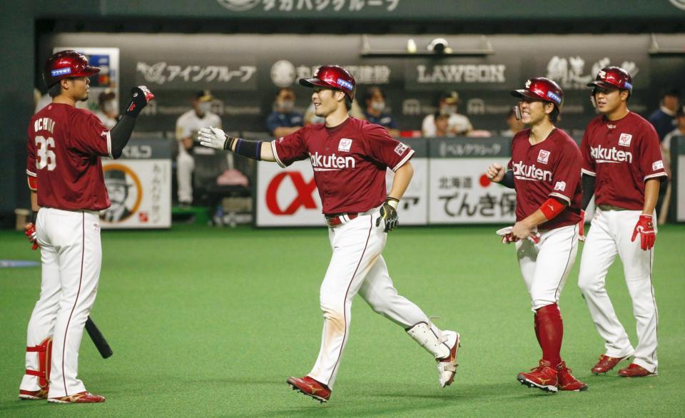 　９回、同点３ランを放ち、内田（左端）に迎えられる楽天・島内＝札幌ドーム