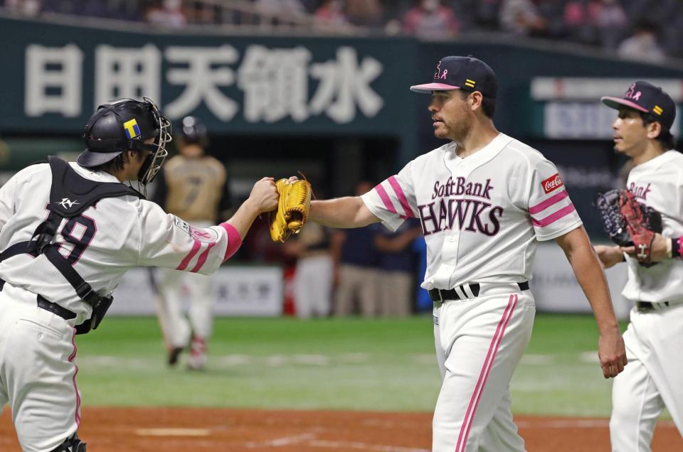 　５回を投げ終え、甲斐（左）とタッチを交わすムーア