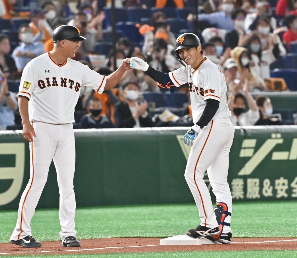 ２回、右中間へ適時三塁打を放ち後藤コーチと笑顔でタッチをかわす高橋（右）＝東京ドーム
