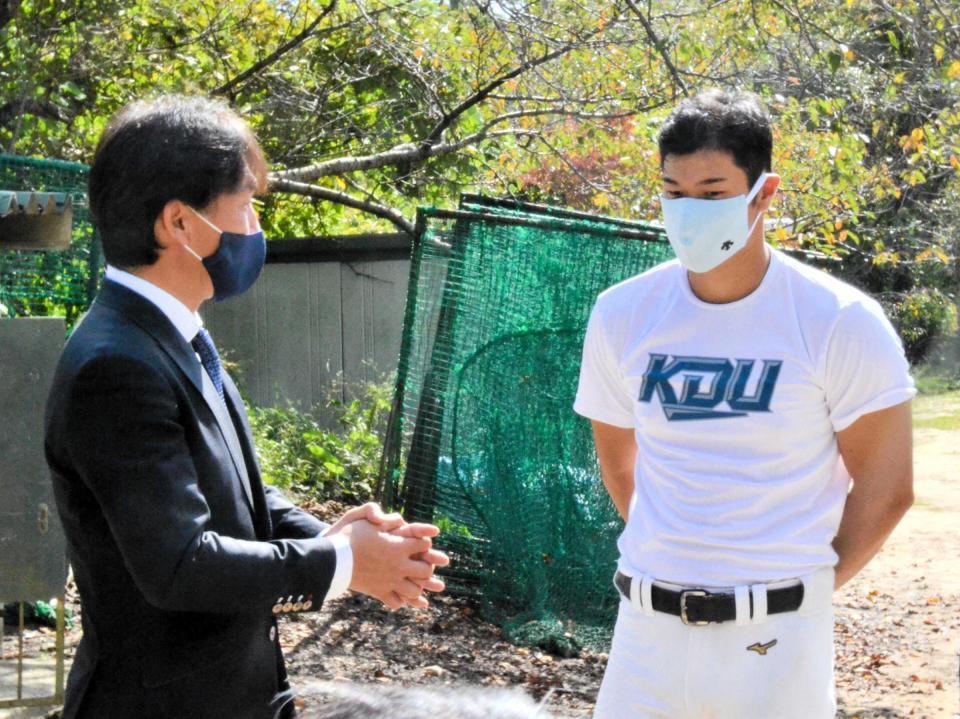 　近大・佐藤に、ドラフト１位指名を公表したことを伝えるオリックス・牧田編成部副部長（左）