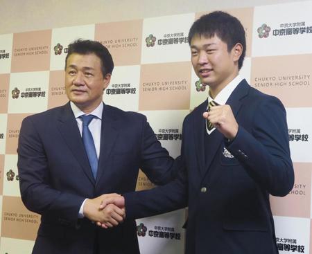 　指名あいさつのため中京大中京高を訪れた中日の与田監督（左）と握手する高橋宏斗投手（共同）