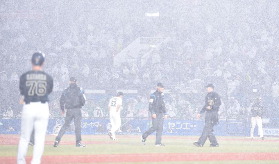 ９回、雨脚が強まり試合を中断する審判団＝ＺＯＺＯマリン（撮影・開出牧）