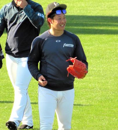 　キャッチボールを終え、笑顔で引き上げる日本ハム・吉田輝