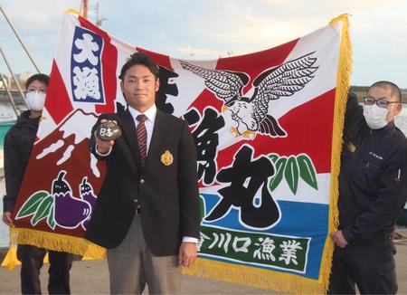 　大漁旗をバックに１年目からの活躍を誓う日本ハムからドラフト１位指名された苫小牧駒大の伊藤大海投手（中央）