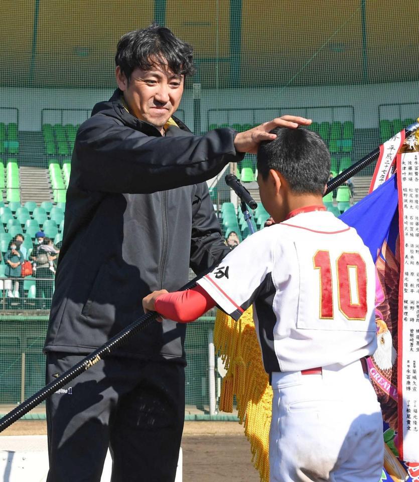 　優勝旗を手渡し、選手の頭をなでるソフトバンク・内川