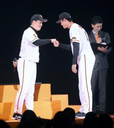 　巨人の新入団発表で原監督（左）とグータッチを交わす平内龍太投手＝１１日午後、東京・両国国技館