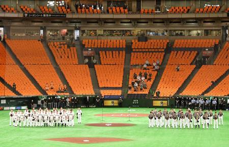 　約３カ月遅れの開幕戦を前に、国歌斉唱で整列する巨人（左）と阪神の選手。史上初の無観客試合で開催された＝６月１９日、東京ドーム
