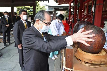 　幸運をもたらすとされる木製の玉に触れる王会長。左後方は工藤監督（代表撮影）