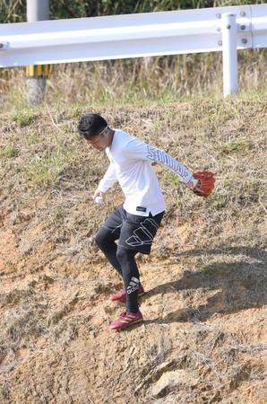 　崖の上に飛んでいったボールを拾い、崖を下る則本昂（撮影・棚橋慶太）