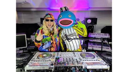 　謎の魚のデビュー曲が「ナゾノサカナ」決まり、ＴＲＦリーダー「ＤＪ　ＫＯＯ」と記念撮影する謎の魚（球団提供）