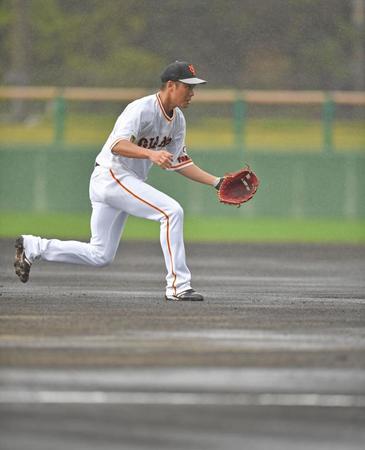 　雨で水が浮いたグラウンドの中でノックを受ける巨人・坂本勇人（撮影・伊藤笙子）