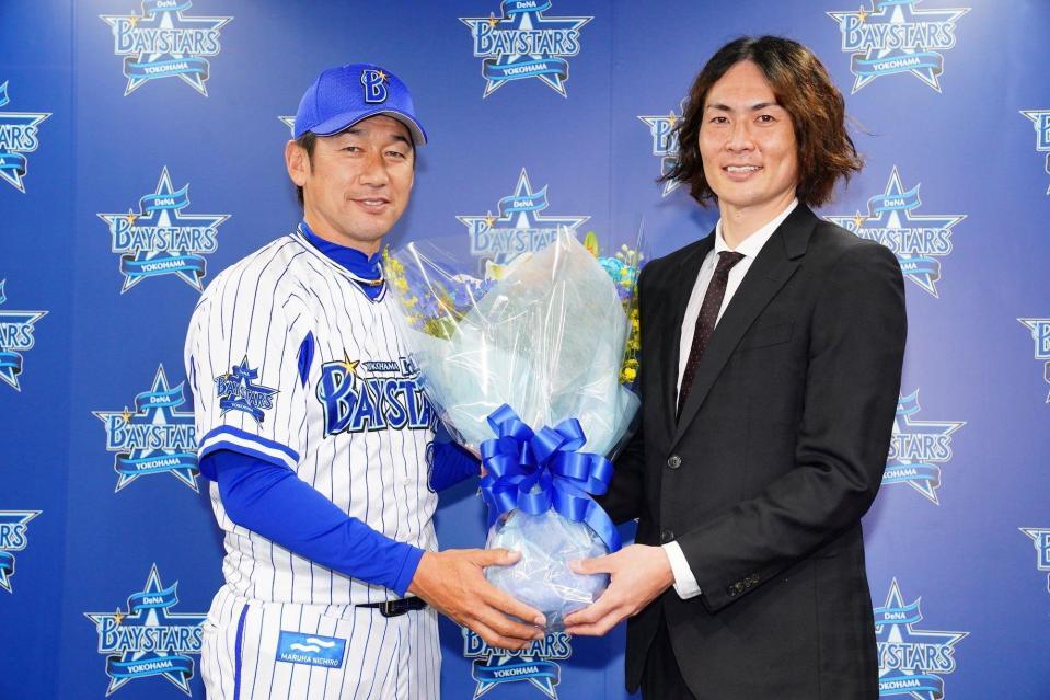 　引退会見でＤｅＮＡ・三浦大輔監督（左）から花束を受ける石川雄洋氏（写真・球団提供）
