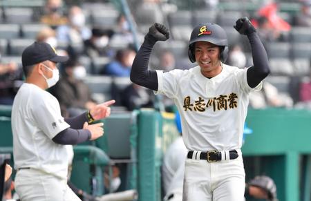 　２回、先制２点打を放った具志川商・上原がガッツポーズでベンチへ戻る。左は喜舎場監督（撮影・吉澤敬太）
