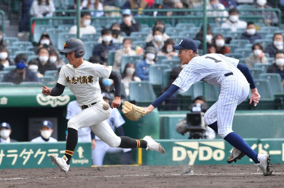 ４回具志川商１死一、三塁、大城勢武太のスクイズで生還する三走・知名椋平。右は八戸西先発・福島蓮＝甲子園球場（撮影・吉澤敬太）