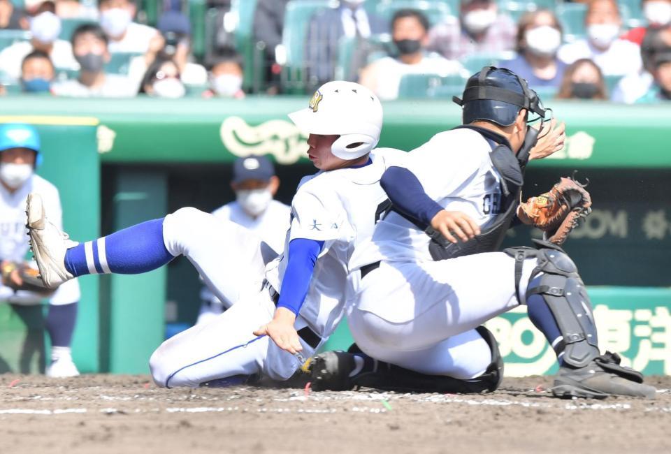 ４回、塘原俊平の先制左犠飛で生還する明豊の三走・竹下聖人。捕手は中京大中京・加藤優翔（撮影・吉澤敬太）