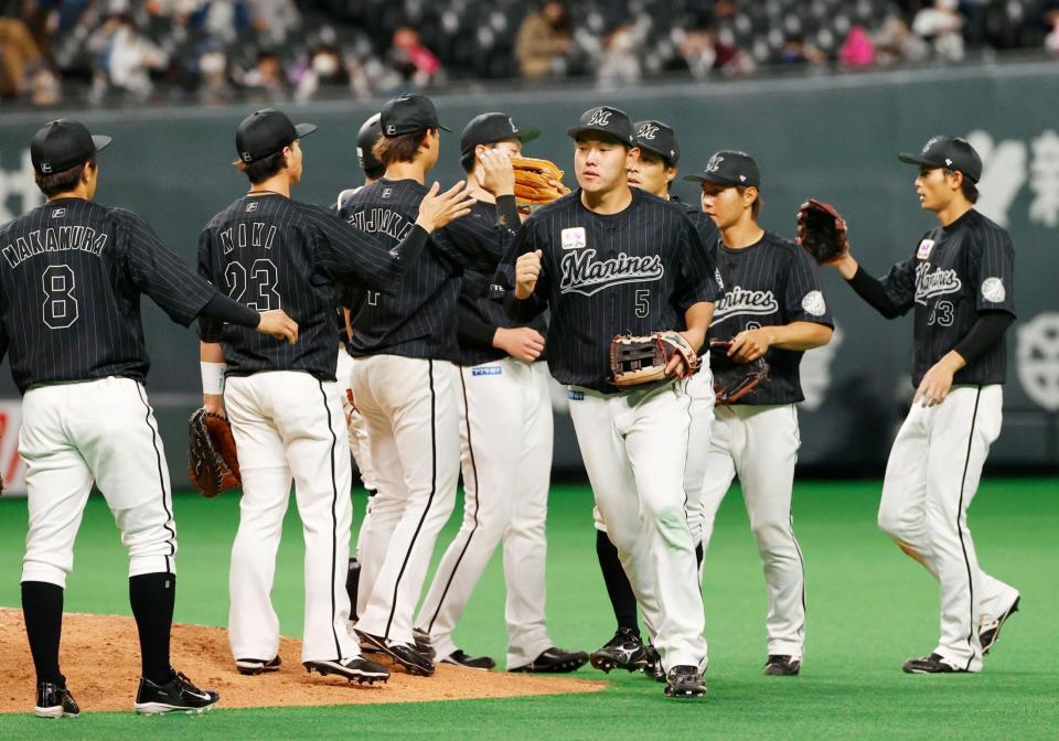 　日本ハムに大勝し、タッチを交わす安田（中央）らロッテナイン＝札幌ドーム