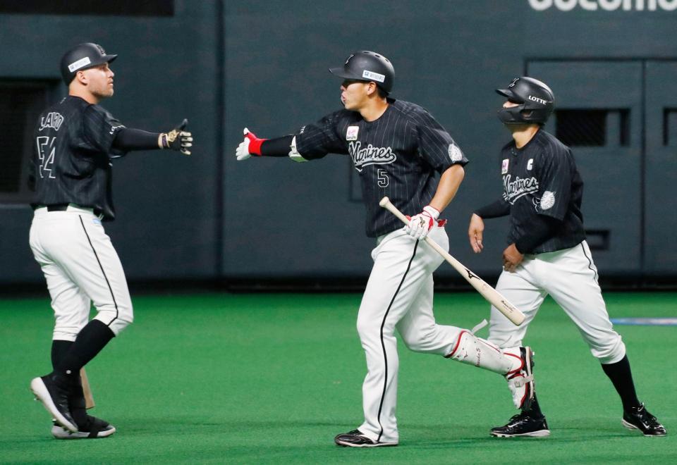 　２回、レアード（左）に迎えられるロッテ・安田＝札幌ドーム