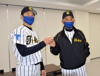 　先発した斎藤からウイニングボールを受け取る東海大・井尻監督（右）