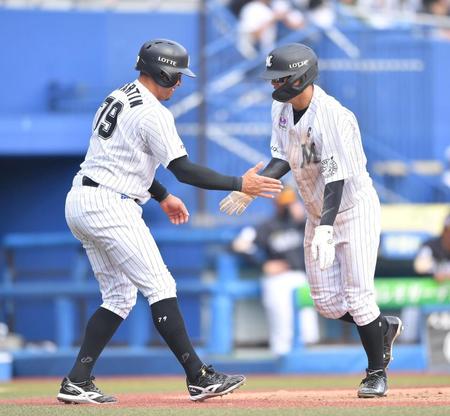 　３回、角中の犠飛で二塁から生還した二走・中村奨（右）と出迎える三走・マーティン（撮影・伊藤笙子）