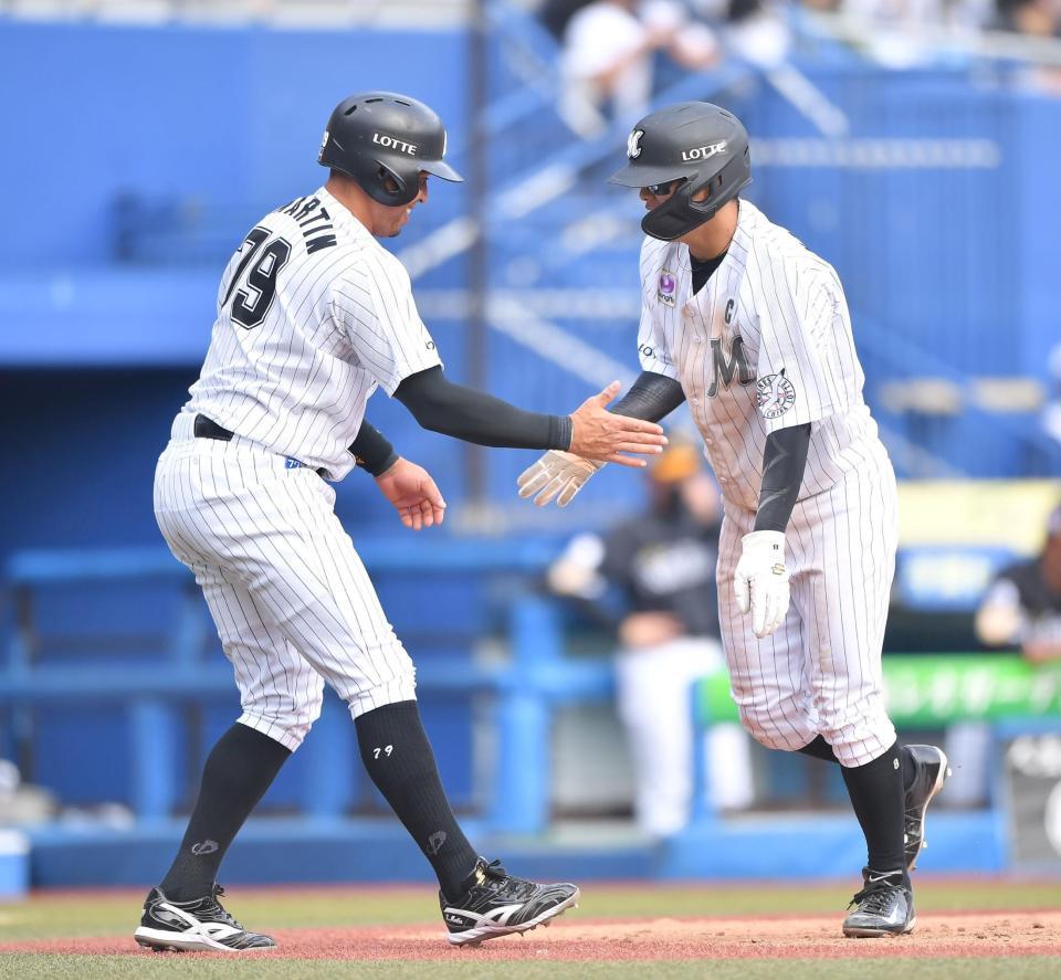 　３回、角中の犠飛で二塁から生還した二走・中村奨（右）と出迎える三走・マーティン（撮影・伊藤笙子）