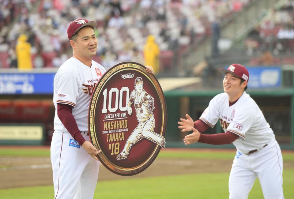 　松井からＮＰＢ１００勝の記念ボードを渡され笑顔の田中将（撮影・金田祐二）