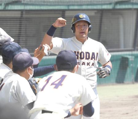 　１回、大商大・犬飼慶樹の適時打で生還する大商大・福元は拳を握る