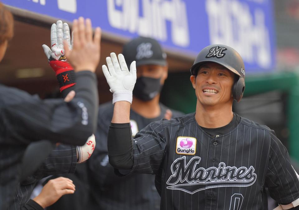 　９、勝ち越しソロを放ち、ナインにタッチで迎えられるロッテ・荻野（右）