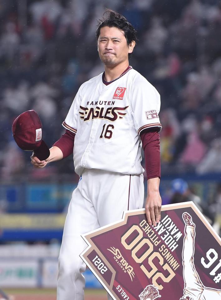 　２５００投球回を達成しボードを手にスタンドの拍手に応える涌井（撮影・開出牧）