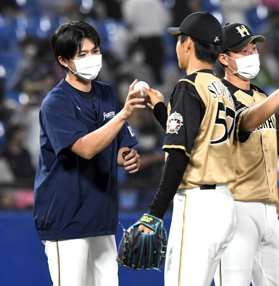 　古巣相手に９回を締めた杉浦（右）からウイニングボールを受け取る上沢