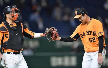 ２回、無失点に抑えて大城（左）とタッチを交わす巨人・横川＝東京ドーム（撮影・西岡正）