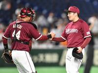 最後を締め、足立（左）とタッチを交わす楽天・松井＝東京ドーム（撮影・西岡正）