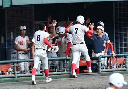 ８回、京都国際の守備の乱れで、三走の智弁学園・前川と二塁走者の岡島が生還しナインが迎える（撮影・山口登）