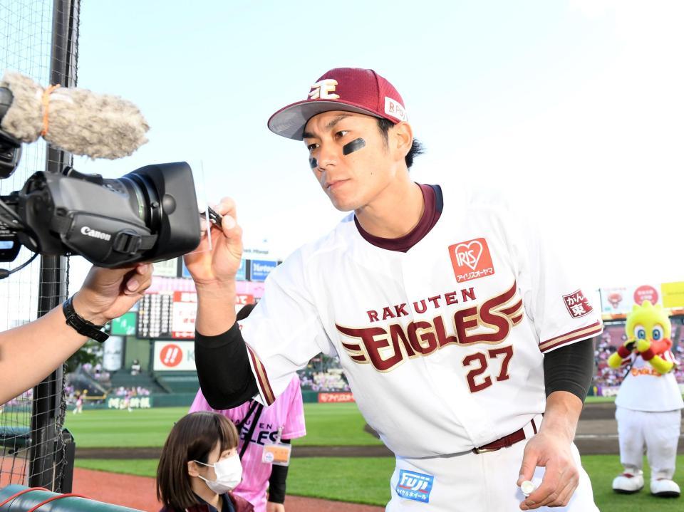 カメラにサインを書き込む岡島（撮影・佐藤厚）