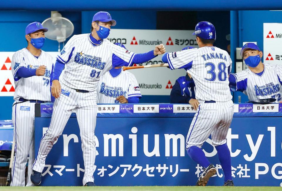 ７回、大和の勝ち越し二塁打で生還した二走田中俊を迎える三浦監督（左から２人目）＝横浜
