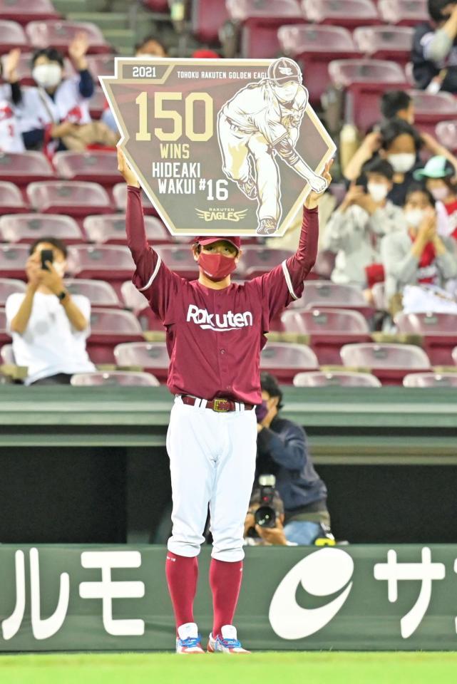 　通算１５０勝目を挙げ、記念パネルを掲げる涌井（撮影・立川洋一郎）