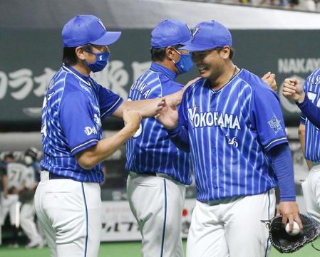 　完封で４勝目を挙げた浜口（右）を迎える三浦監督