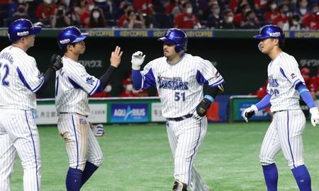 ９回、宮崎（中央右）が左中間へ満塁本塁打を放ち、ナインに迎えられる＝東京ドーム