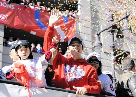 　ワールドシリーズの優勝パレードで、長男の寛君（左）ら家族と手を振る笑顔のフィリーズ・田口＝２００８年１０月３１日、フィラデルフィア市内（共同）