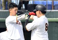 　腕の長さを比べる岡本和（左）と丸（撮影・佐藤厚）