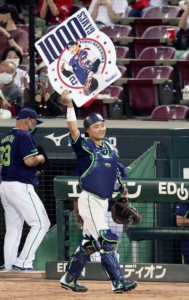 通算１０００試合出場を達成し、ボードを掲げるヤクルト・中村＝マツダ