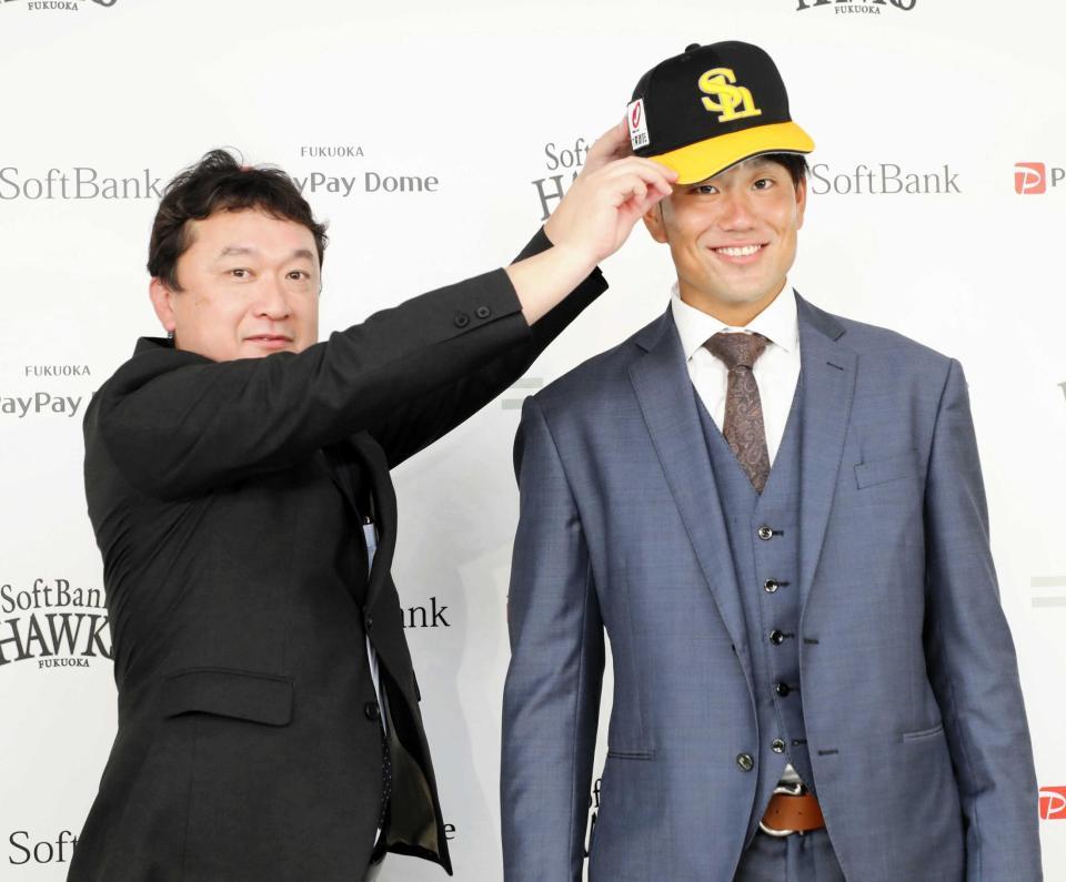 　三笠ＧＭに帽子をかぶせてもらう中谷（球団提供）