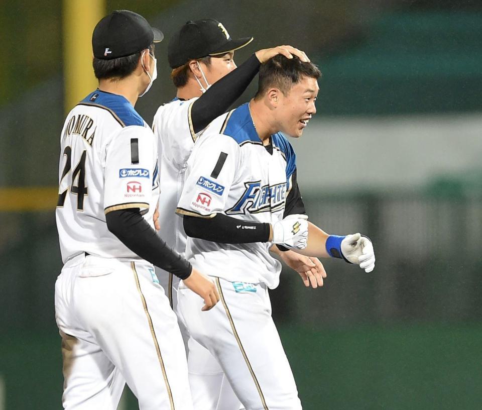 　９回、中越えにサヨナラ二塁打を放ち、ナインに祝福される高浜（右端）