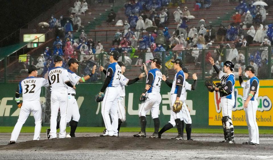 　西武に連勝しタッチを交わす日本ハムナイン＝旭川