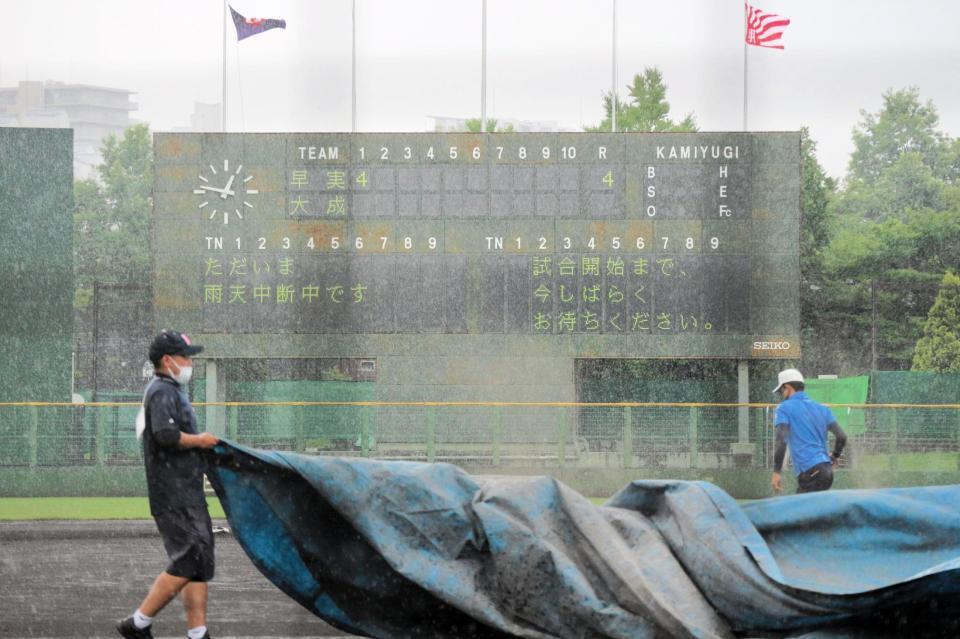 １回表終了後雨脚が強まりシートがかけられる