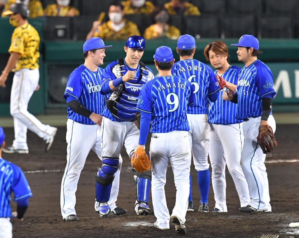 阪神に競り勝ちタッチを交わす（右から）宮崎、三嶋らＤｅＮＡナイン＝甲子園球場（撮影・吉澤敬太）